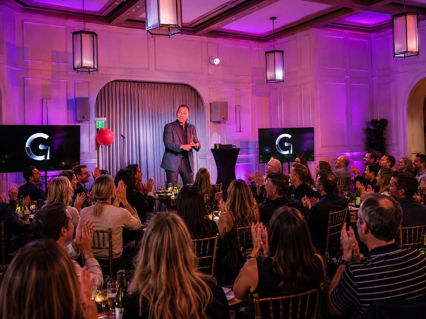 Guy Bavli performing for seated guests at a ballroom dinner