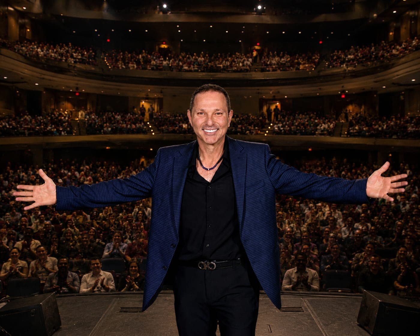Guy Bavli on a theater stage in front of a full house