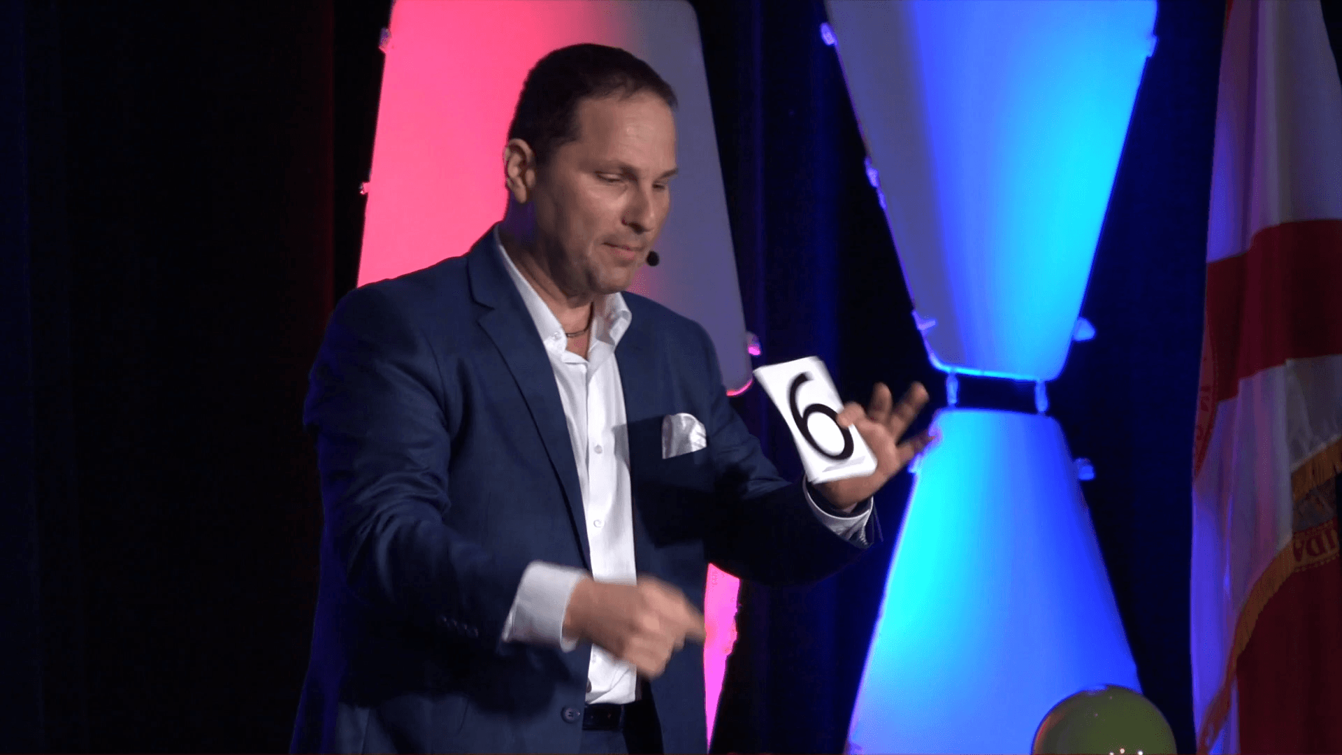 Guy Bavli revealing the number six on stage
