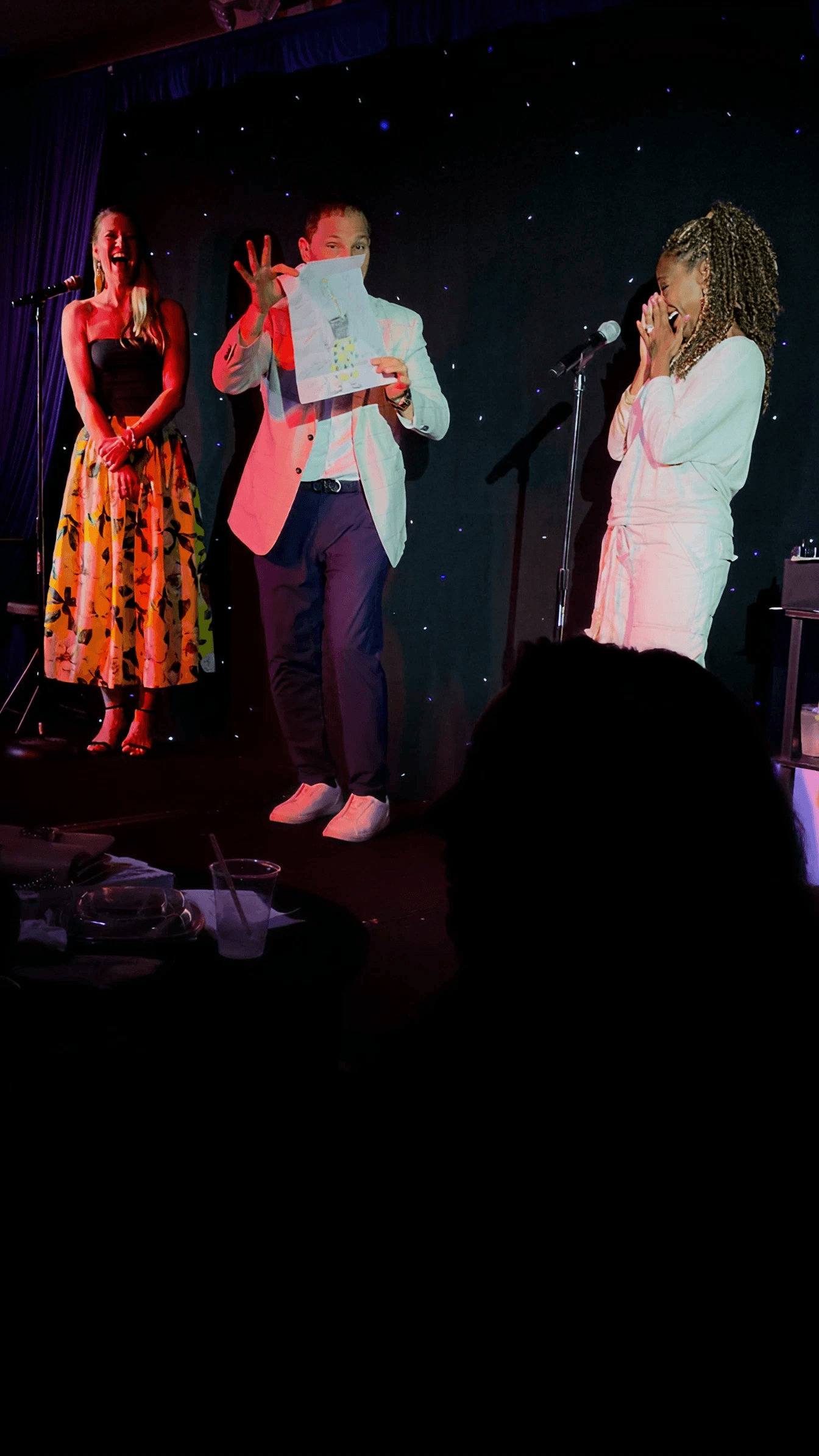 Guy Bavli on stage with two volunteers